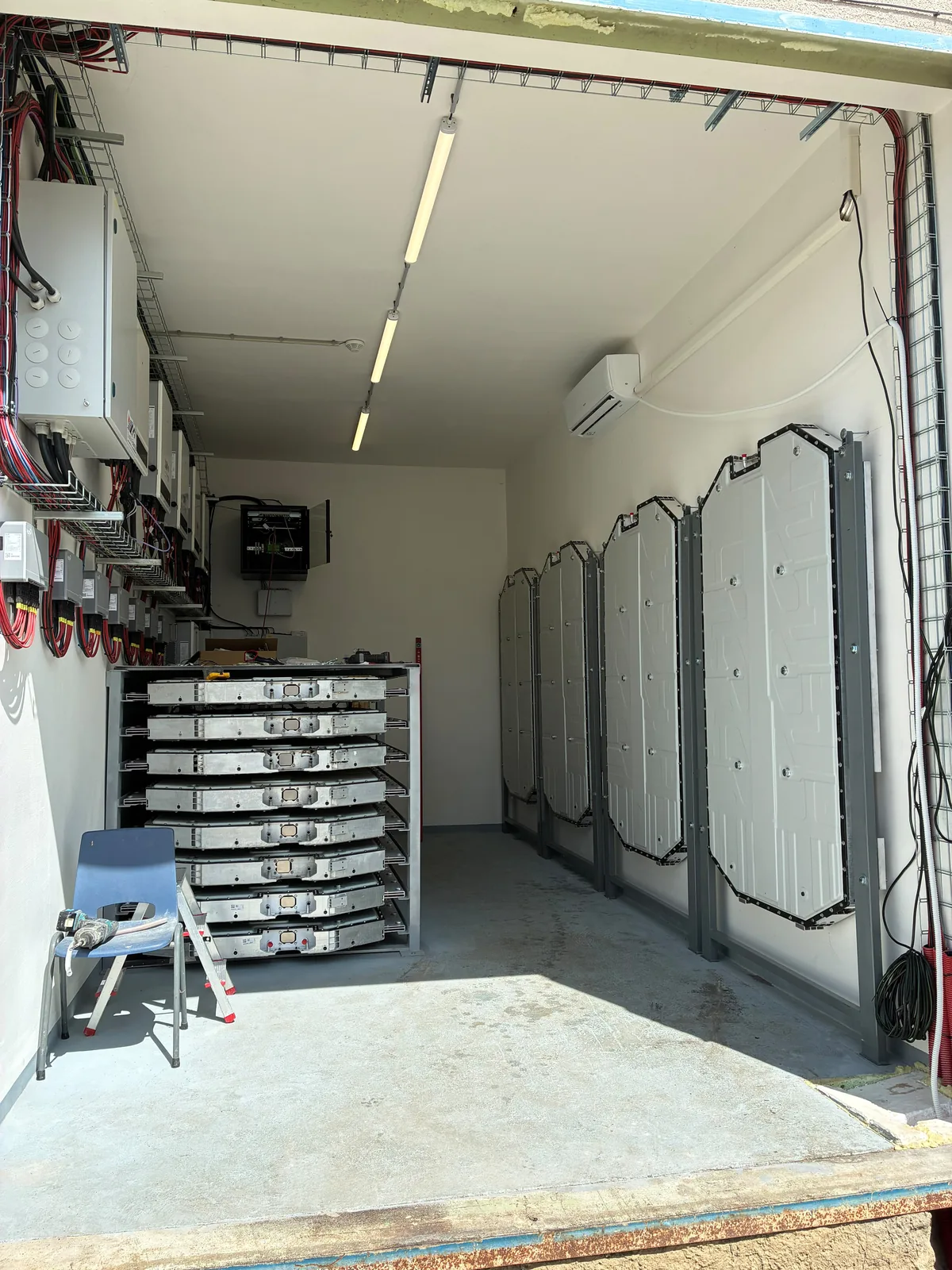 Bateriové úložiště: moduly z elektromobilů Kia EV6 v regálu a bateriové pakety na stěně